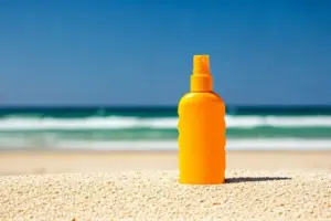 a bottle of yellow sunscreen on the beach